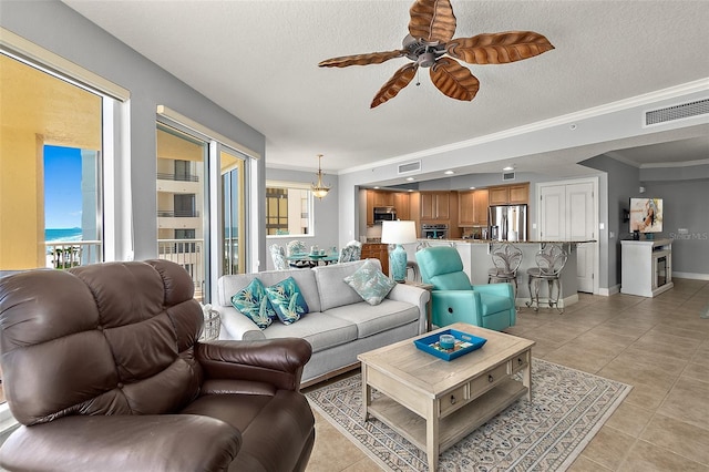 2901 S Atlantic Ave Unit 603, Daytona Beach Shores, FL 32118 - living room featuring a ceiling fan, light tile patterned floors, ornamental molding, and a textured ceiling