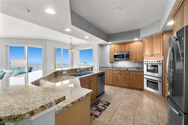 2901 S Atlantic Ave Unit 603, Daytona Beach Shores, FL 32118 - kitchen with stainless steel appliances, light tile patterned floors, recessed lighting, a large island, and brown cabinets