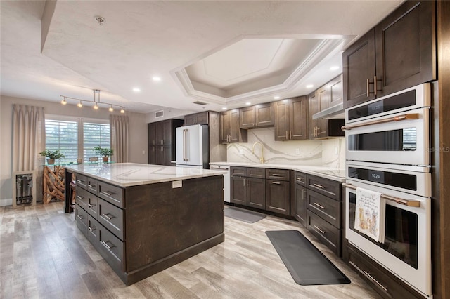 1 John Anderson Dr Unit 1030, Ormond Beach, FL 32176 - kitchen with white appliances, a tray ceiling, light wood-type flooring, dark brown cabinetry, and recessed lighting