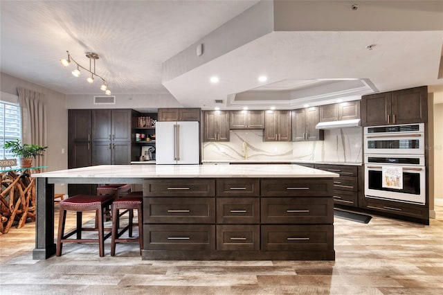 1 John Anderson Dr Unit 1030, Ormond Beach, FL 32176 - kitchen featuring white appliances, light wood-style flooring, open shelves, dark brown cabinets, and a spacious island
