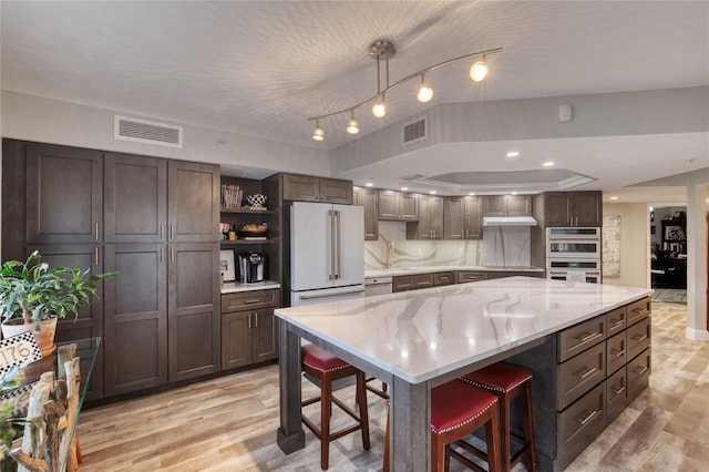 1 John Anderson Dr Unit 1030, Ormond Beach, FL 32176 - kitchen featuring freestanding refrigerator, open shelves, double oven, a breakfast bar area, and light wood-type flooring