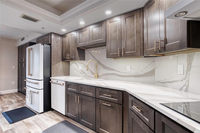 1 John Anderson Dr Unit 1030, Ormond Beach, FL 32176 - kitchen featuring white appliances, exhaust hood, dark brown cabinetry, crown molding, and backsplash
