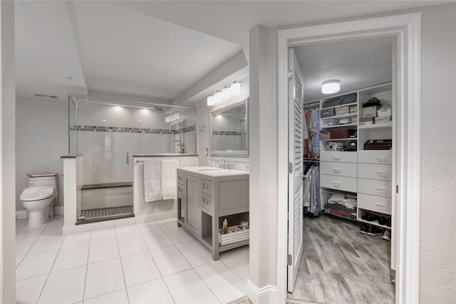 1 John Anderson Dr Unit 1030, Ormond Beach, FL 32176 - full bathroom featuring a walk in closet, vanity, a stall shower, and tile patterned floors