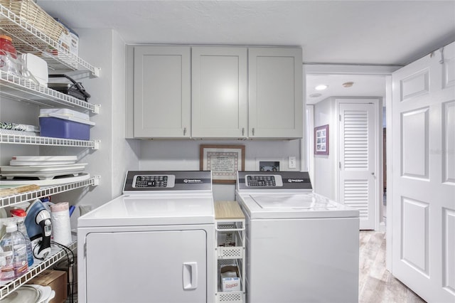 1 John Anderson Dr Unit 1030, Ormond Beach, FL 32176 - laundry room featuring independent washer and dryer, cabinet space, and light wood-type flooring