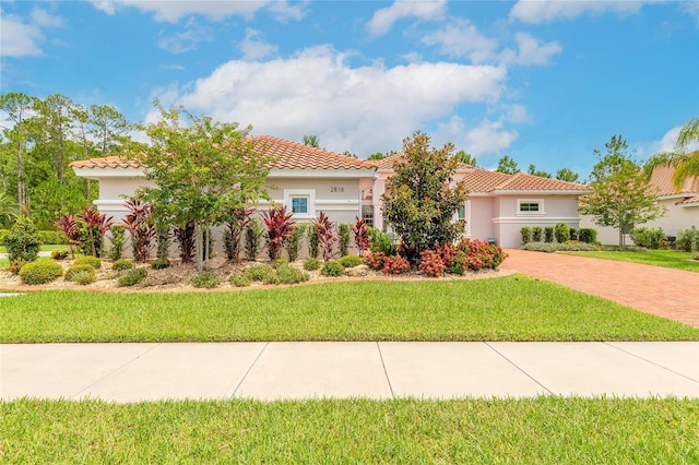 2816 E Venetian Lake Cir, New Smyrna Beach, FL 32168 - mediterranean / spanish home with a front lawn, stucco siding, and a tile roof