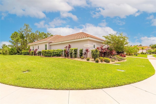 2816 E Venetian Lake Cir, New Smyrna Beach, FL 32168 - view of property exterior with a tiled roof, a yard, and stucco siding