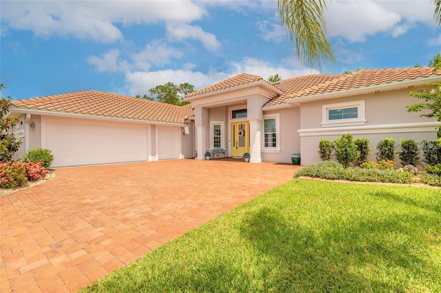 2816 E Venetian Lake Cir, New Smyrna Beach, FL 32168 - mediterranean / spanish-style house with decorative driveway, a tile roof, an attached garage, and stucco siding