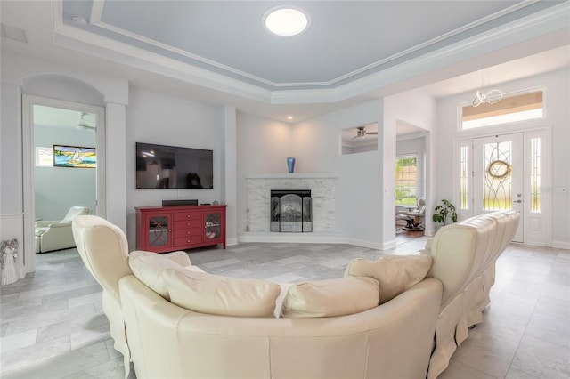 2816 E Venetian Lake Cir, New Smyrna Beach, FL 32168 - living room featuring a raised ceiling, a fireplace, crown molding, and light tile patterned flooring