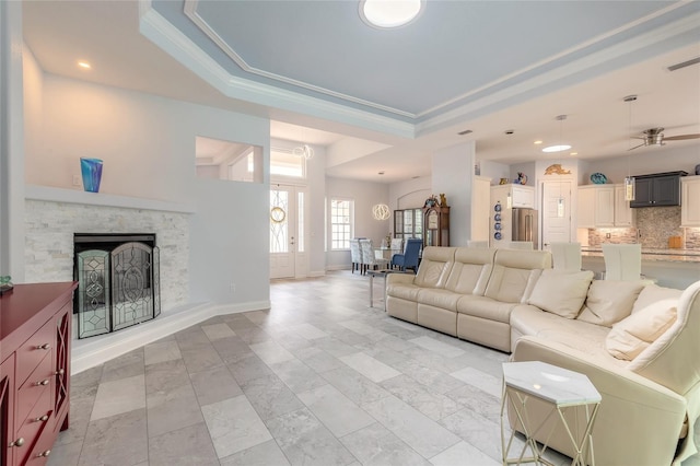 2816 E Venetian Lake Cir, New Smyrna Beach, FL 32168 - living area with a raised ceiling, a ceiling fan, recessed lighting, a fireplace, and ornamental molding