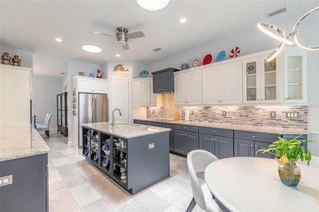 2816 E Venetian Lake Cir, New Smyrna Beach, FL 32168 - kitchen featuring a ceiling fan, backsplash, a kitchen island with sink, freestanding refrigerator, and recessed lighting