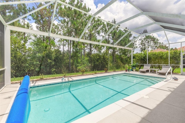 2816 E Venetian Lake Cir, New Smyrna Beach, FL 32168 - outdoor pool featuring a patio area, glass enclosure, and view of scattered trees