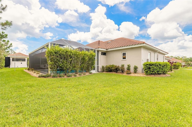 2816 E Venetian Lake Cir, New Smyrna Beach, FL 32168 - rear view of house featuring a tiled roof, a lawn, stucco siding, and a lanai