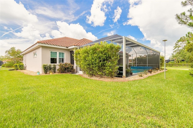 2816 E Venetian Lake Cir, New Smyrna Beach, FL 32168 - back of property with a tiled roof, stucco siding, a yard, and a lanai