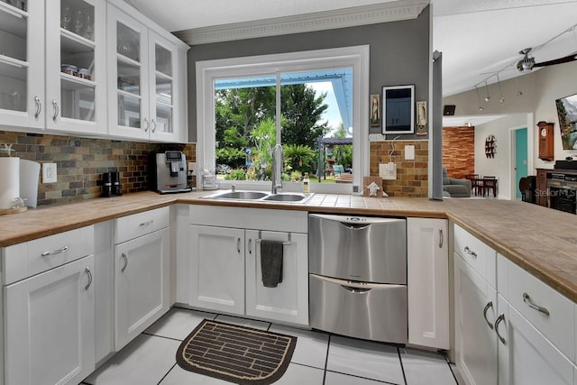 1366 Valhalla St, Deltona, FL 32725 - kitchen featuring stainless steel dishwasher, decorative backsplash, light tile patterned floors, white cabinetry, and crown molding