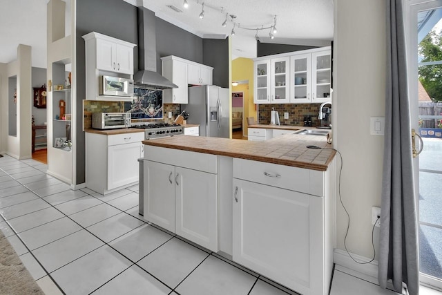 1366 Valhalla St, Deltona, FL 32725 - kitchen featuring appliances with stainless steel finishes, wall chimney exhaust hood, decorative backsplash, glass insert cabinets, and a peninsula