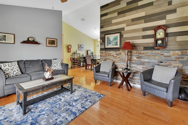 1366 Valhalla St, Deltona, FL 32725 - living area featuring vaulted ceiling, ceiling fan, light wood-style floors, an accent wall, and wooden walls
