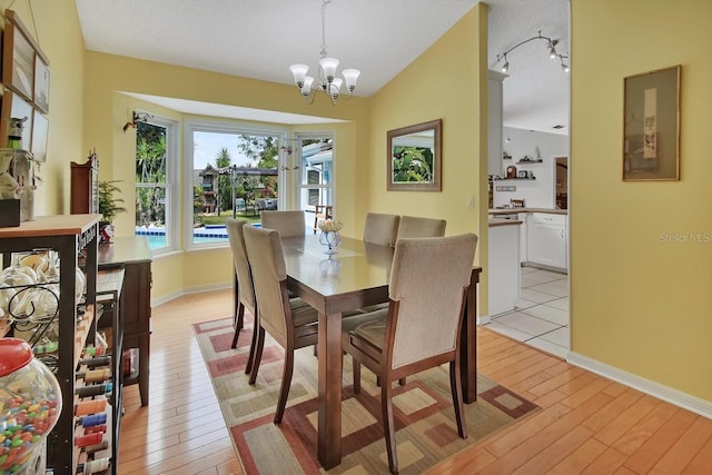1366 Valhalla St, Deltona, FL 32725 - dining area with a chandelier, light wood-style floors, and vaulted ceiling