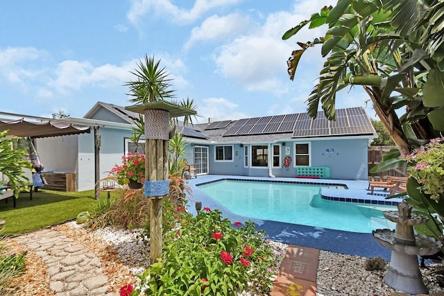 1366 Valhalla St, Deltona, FL 32725 - back of house featuring roof mounted solar panels, a patio, and an outdoor pool
