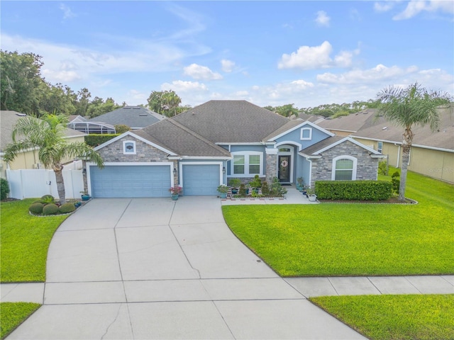 710 Grape Ivy Ln, New Smyrna Beach, FL 32168 - view of front of house with stone siding, a garage, driveway, and stucco siding