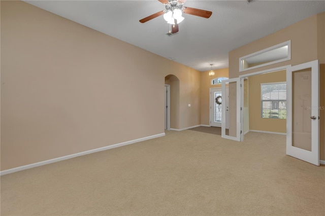 710 Grape Ivy Ln, New Smyrna Beach, FL 32168 - spare room featuring arched walkways, french doors, light carpet, and ceiling fan