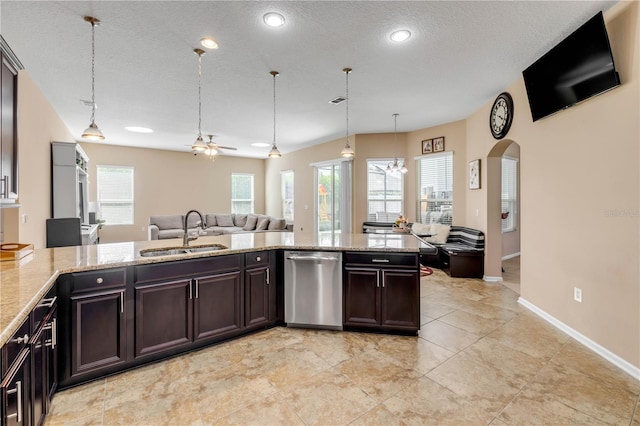 710 Grape Ivy Ln, New Smyrna Beach, FL 32168 - kitchen with stainless steel dishwasher, open floor plan, light stone counters, arched walkways, and a textured ceiling
