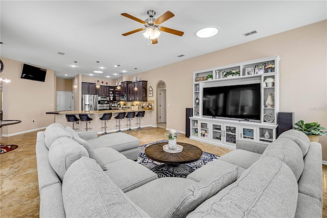 710 Grape Ivy Ln, New Smyrna Beach, FL 32168 - living room with arched walkways, ceiling fan, and light tile patterned floors