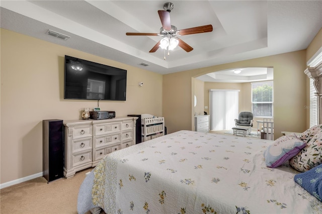 710 Grape Ivy Ln, New Smyrna Beach, FL 32168 - bedroom featuring a raised ceiling, arched walkways, light carpet, and ceiling fan