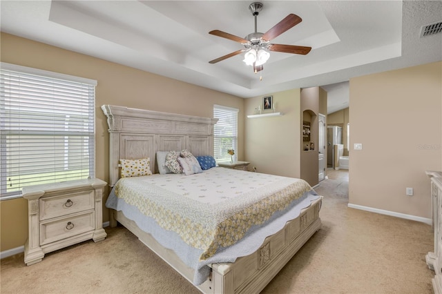710 Grape Ivy Ln, New Smyrna Beach, FL 32168 - bedroom featuring a tray ceiling, light carpet, arched walkways, and a ceiling fan