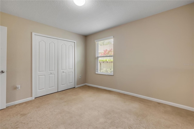 710 Grape Ivy Ln, New Smyrna Beach, FL 32168 - unfurnished bedroom with carpet floors, a closet, and a textured ceiling