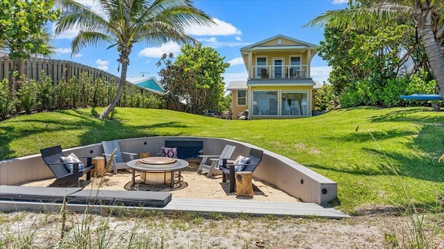943 S Atlantic Ave, Cocoa Beach, FL 32931 - back of property with a fire pit, a balcony, and a sunroom