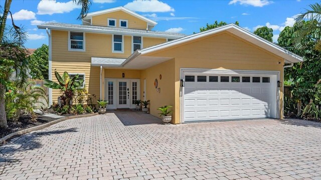 943 S Atlantic Ave, Cocoa Beach, FL 32931 - view of front of home with french doors, decorative driveway, a garage, and stucco siding