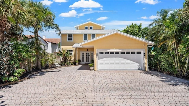 943 S Atlantic Ave, Cocoa Beach, FL 32931 - view of front of house with decorative driveway, a garage, and french doors