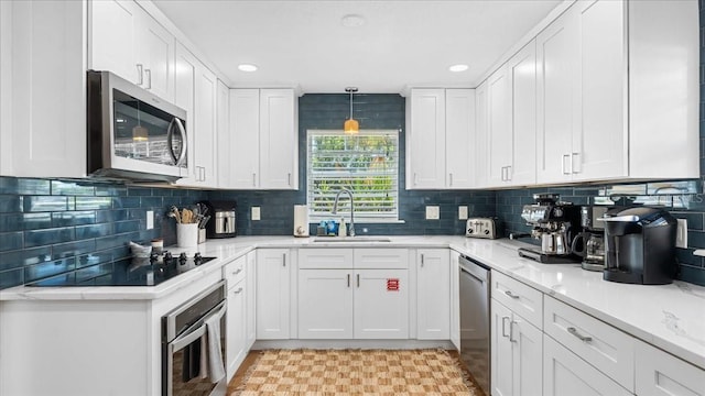 943 S Atlantic Ave, Cocoa Beach, FL 32931 - kitchen with stainless steel appliances, white cabinetry, tasteful backsplash, recessed lighting, and light stone countertops