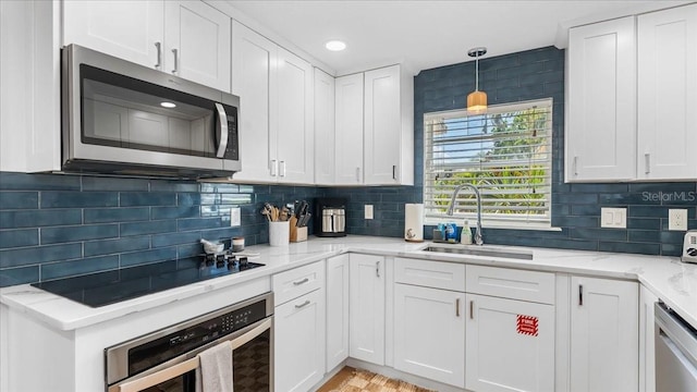 943 S Atlantic Ave, Cocoa Beach, FL 32931 - kitchen with appliances with stainless steel finishes, white cabinetry, decorative backsplash, light stone countertops, and pendant lighting