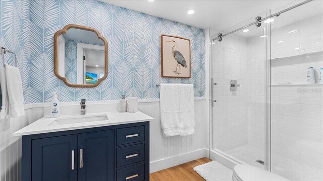 943 S Atlantic Ave, Cocoa Beach, FL 32931 - bathroom featuring wallpapered walls, vanity, wood finished floors, a stall shower, and recessed lighting