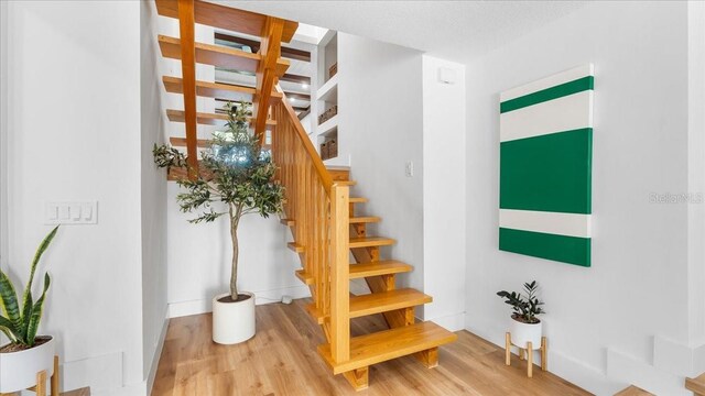 943 S Atlantic Ave, Cocoa Beach, FL 32931 - stairs with wood finished floors and baseboards