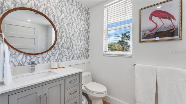 943 S Atlantic Ave, Cocoa Beach, FL 32931 - bathroom with wallpapered walls, vanity, and an accent wall