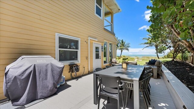 943 S Atlantic Ave, Cocoa Beach, FL 32931 - view of patio with a grill, outdoor dining space, and a deck with water view