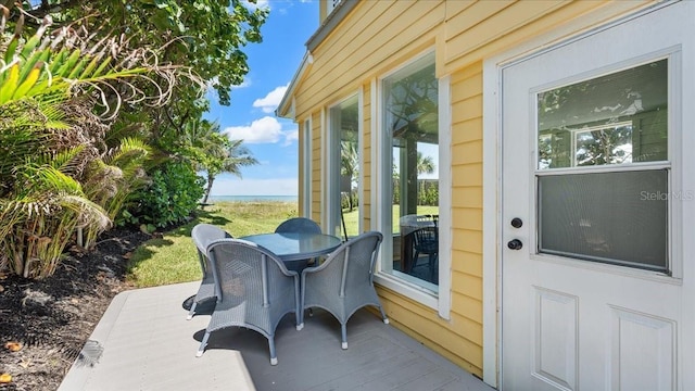 943 S Atlantic Ave, Cocoa Beach, FL 32931 - view of patio with outdoor dining space and a deck with water view
