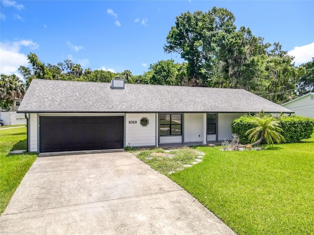 1019 Chippewa Trl, Daytona Beach, FL 32117 - ranch-style house with a front yard, driveway, a garage, and roof with shingles