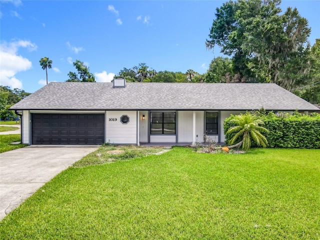 1019 Chippewa Trl, Daytona Beach, FL 32117 - ranch-style house featuring a front yard, an attached garage, concrete driveway, and a shingled roof