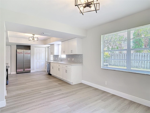 1019 Chippewa Trl, Daytona Beach, FL 32117 - kitchen with stainless steel appliances, a chandelier, light countertops, and light wood-style floors