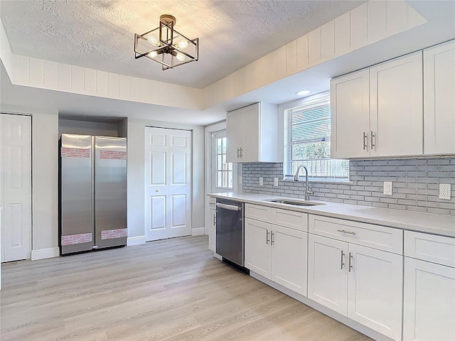 1019 Chippewa Trl, Daytona Beach, FL 32117 - kitchen featuring appliances with stainless steel finishes, light countertops, tasteful backsplash, light wood-type flooring, and a textured ceiling