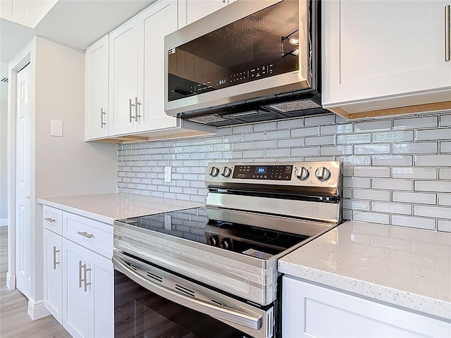 1019 Chippewa Trl, Daytona Beach, FL 32117 - kitchen with appliances with stainless steel finishes, white cabinetry, tasteful backsplash, and light stone counters