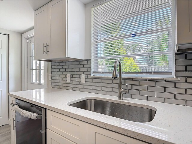 1019 Chippewa Trl, Daytona Beach, FL 32117 - kitchen featuring dishwasher, backsplash, white cabinets, and healthy amount of natural light