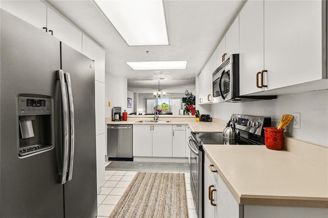 3 Oceans W Blvd Unit 3A7, Daytona Beach Shores, FL 32118 - kitchen with stainless steel appliances, light tile patterned flooring, light countertops, and white cabinets