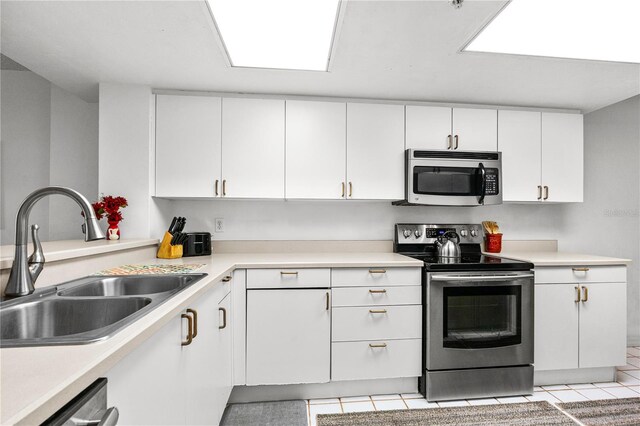3 Oceans W Blvd Unit 3A7, Daytona Beach Shores, FL 32118 - kitchen with appliances with stainless steel finishes, light tile patterned floors, white cabinets, and light countertops