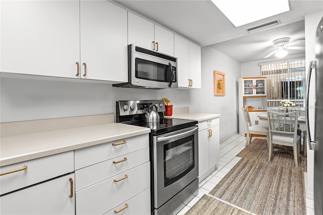 3 Oceans W Blvd Unit 3A7, Daytona Beach Shores, FL 32118 - kitchen featuring stainless steel appliances, light countertops, light tile patterned flooring, and white cabinets