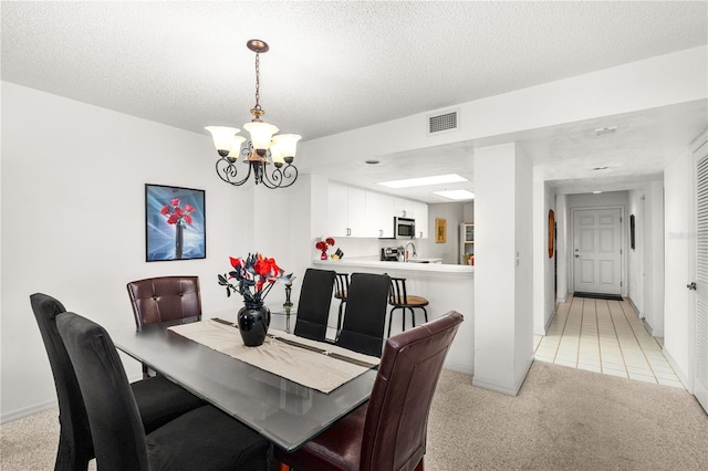 3 Oceans W Blvd Unit 3A7, Daytona Beach Shores, FL 32118 - dining space with a chandelier, light carpet, and a textured ceiling