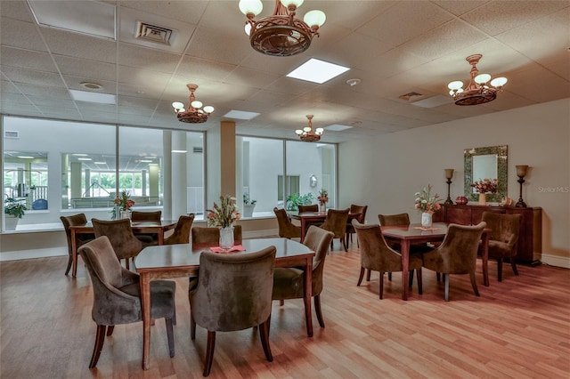 3 Oceans W Blvd Unit 3A7, Daytona Beach Shores, FL 32118 - dining room with a chandelier, light wood-type flooring, and a drop ceiling